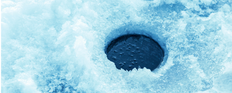 Image of a hole cut in the ice for the purpose of ice fishing in winter