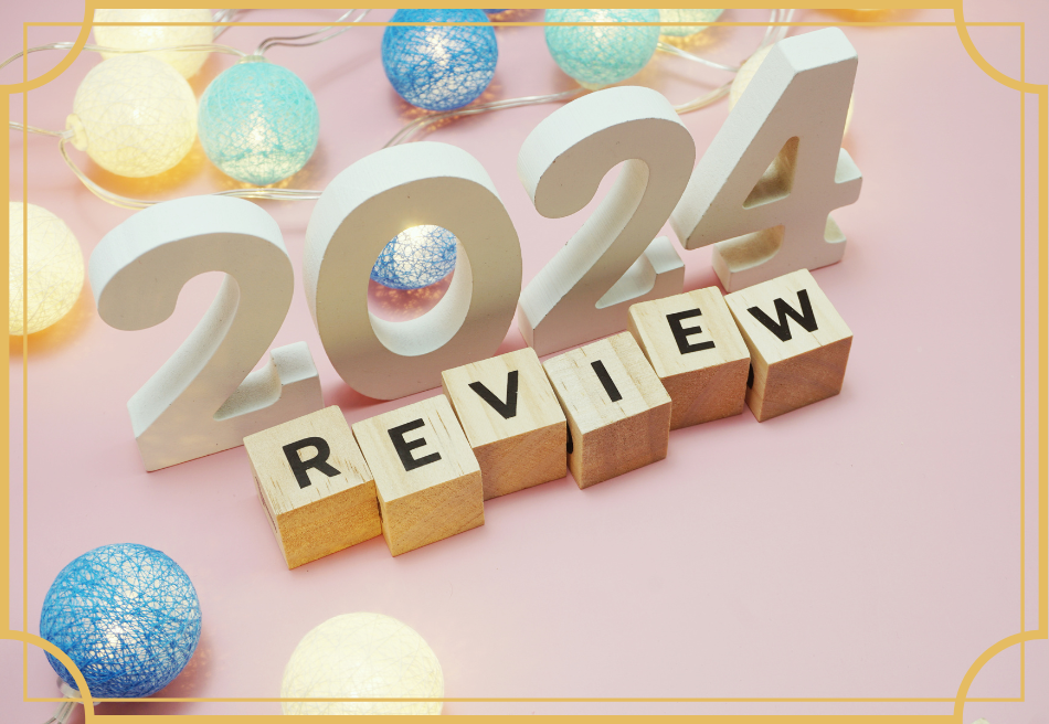 The year 2024 is featured with the word REVIEW spelled out in wooden blocks at the bottom of the year. The background is pink and there are brightly colour balls above and below the central image.